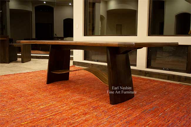 modern designer dining table from below showing wavy zebrawood slats and notched fork joint base